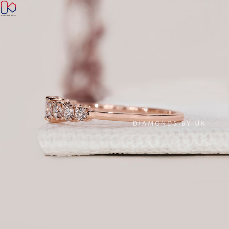 Rose gold engagement ring paired with 7 stone band.
