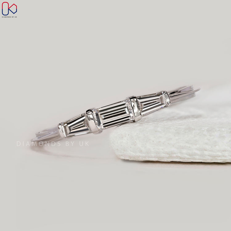 Tapered baguette side diamond wedding band.
