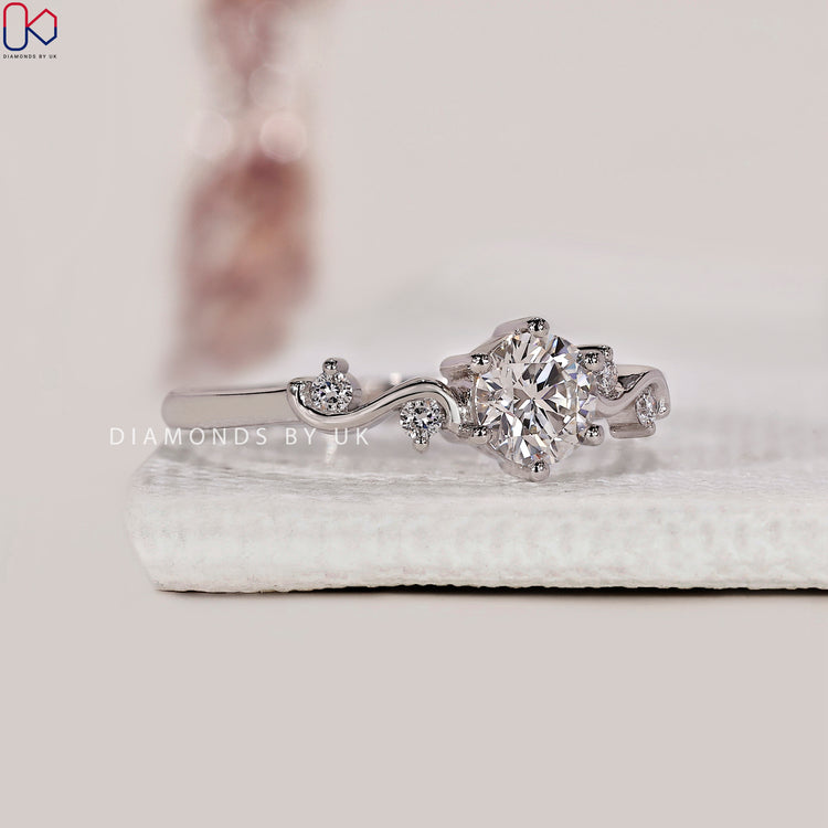 White gold ring with handcrafted filigree details and a round diamond focal point.