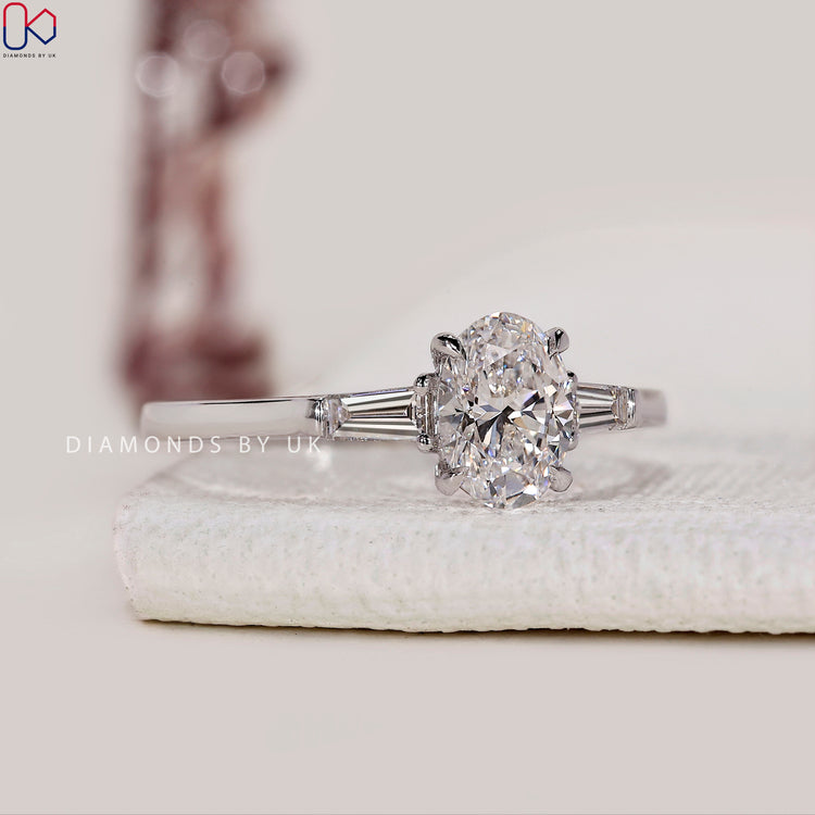 Tapered baguette side stone ring in cathedral setting.
