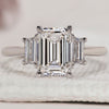 3 stone ring with emerald cut centre and trapezoid side stones.
