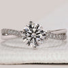 White gold engagement ring with round diamond center.
