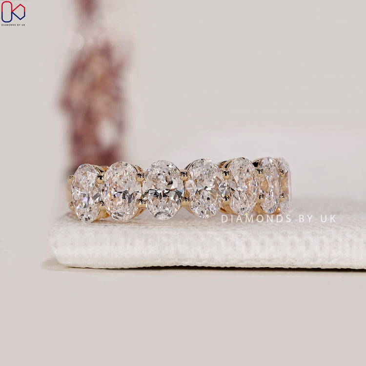 Prong set wedding band with oval cut lab grown diamonds.
