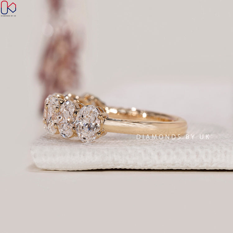Custom wedding band in yellow gold with oval lab grown diamonds.

