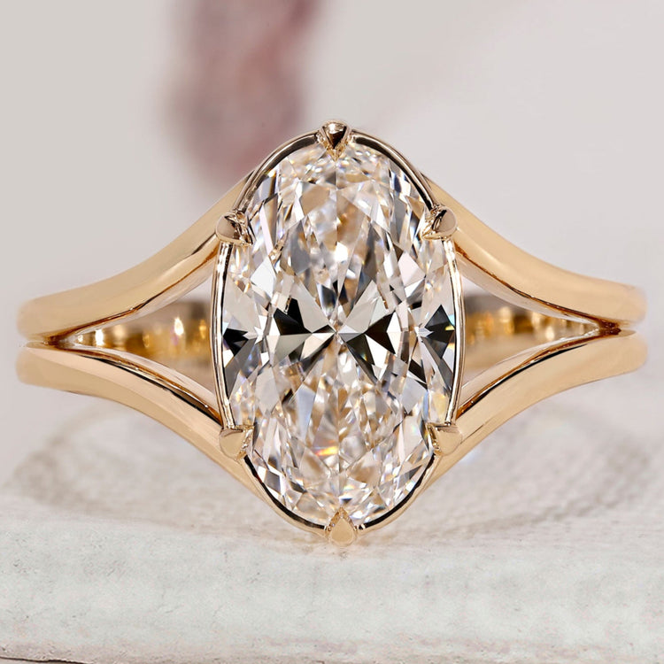Split shank engagement ring with oval cut diamond.
