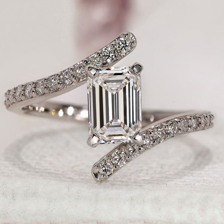 Emerald cut engagement ring with bypass pave setting.
