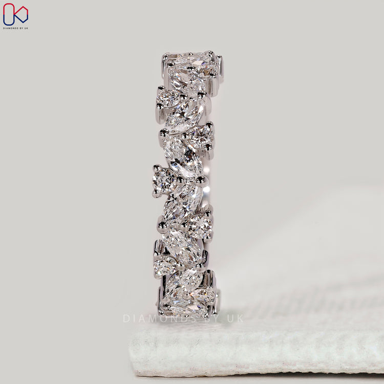 Prong setting wedding band with marquise and round diamonds.
