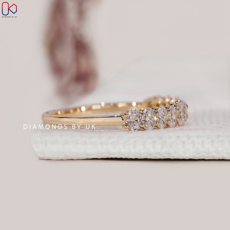 Yellow gold oval diamond wedding band with prong settings.
