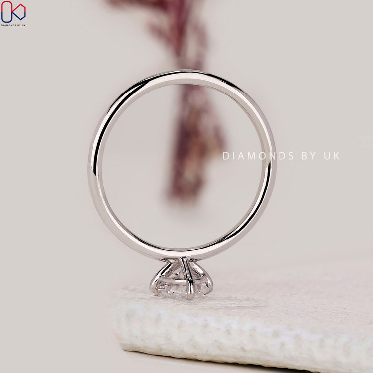 White gold diamond ring with oval solitaire center.
