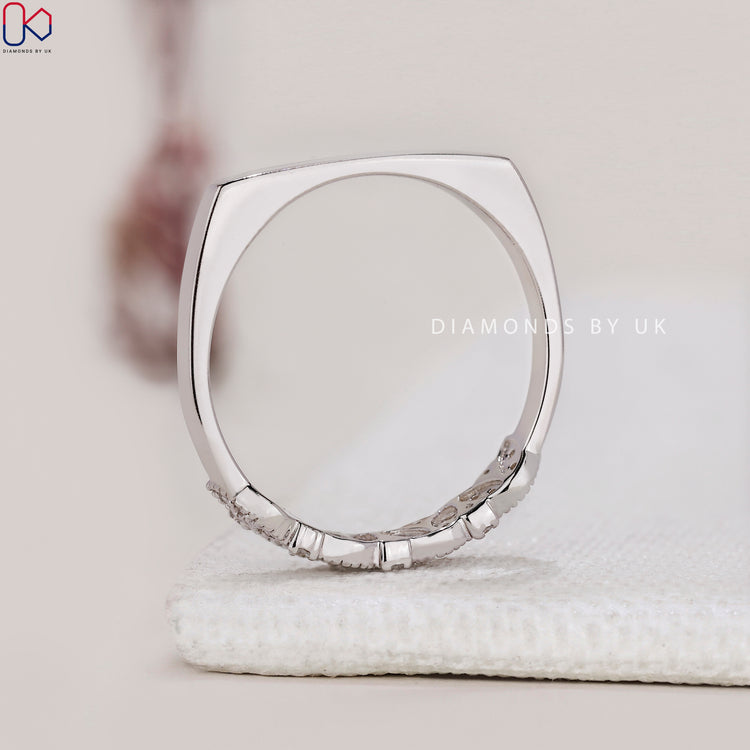 Round cut diamond half eternity ring with marquise outline.
