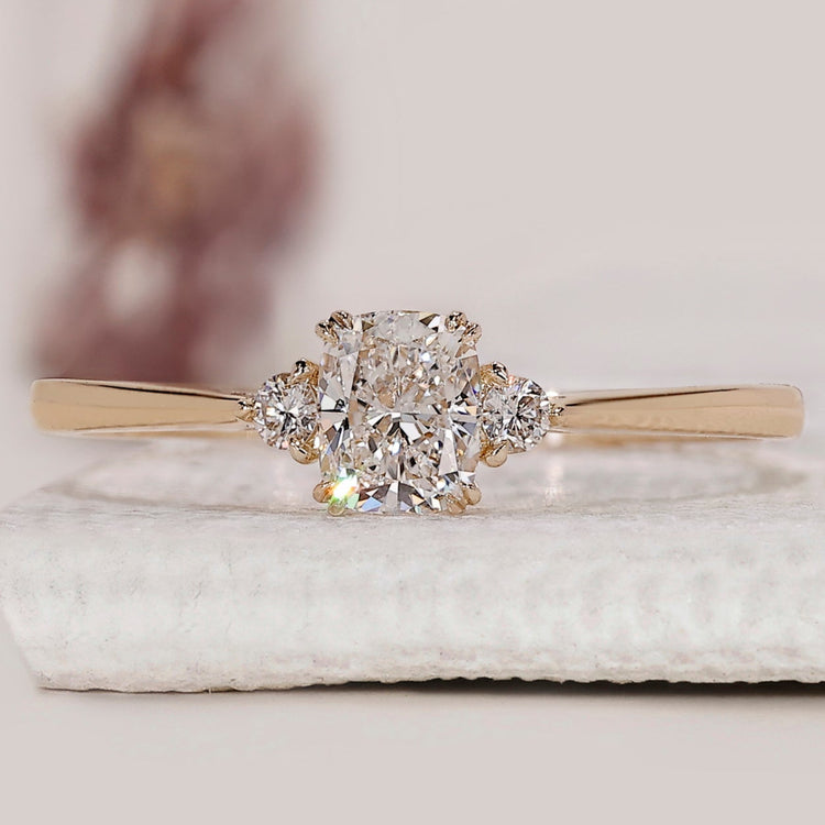 Cushion cut engagement ring with round cut side stones.
