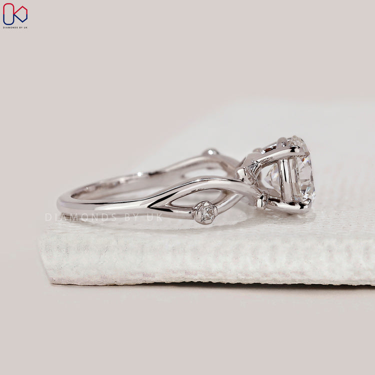 Round side stone engagement ring with white gold band.
