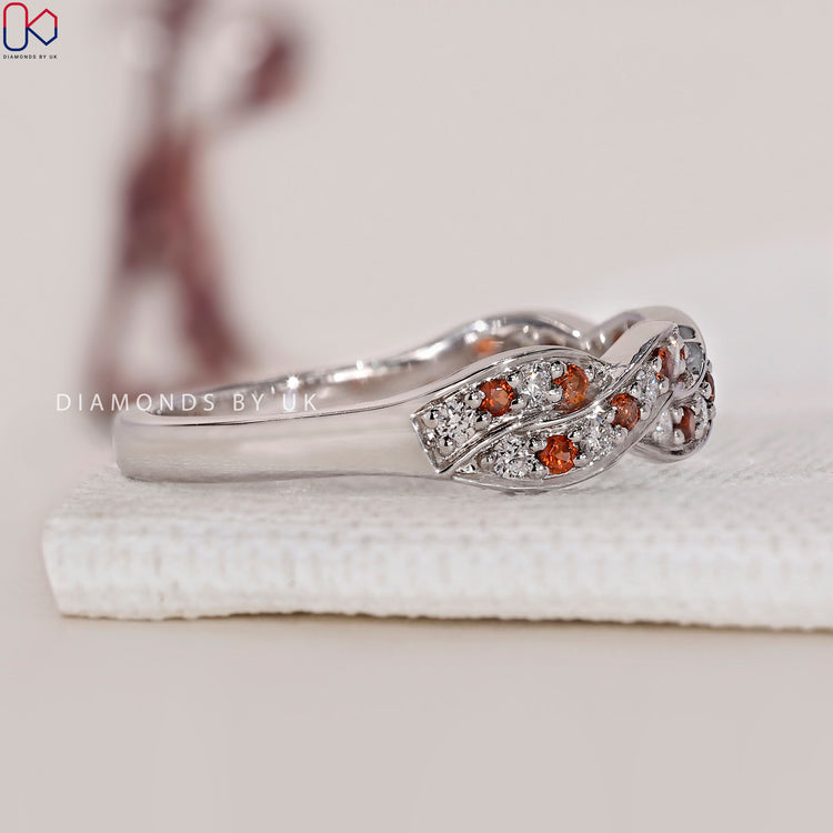 White gold wedding band with a twisted design and diamond accents.
