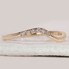 Curved diamond wedding band in yellow gold.

