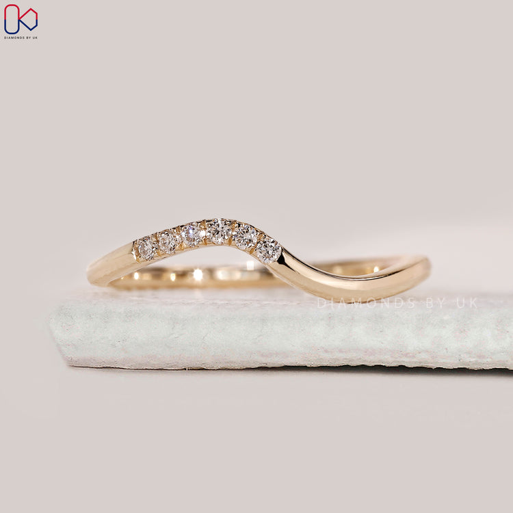 Yellow gold diamond band with curved shape.
