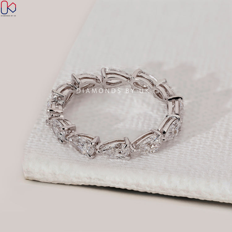 White gold diamond band featuring pear shapes.
