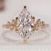 Gold marquise engagement ring with round side stones.
