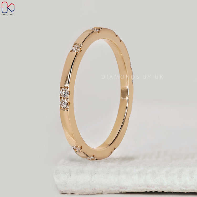 Minimalist yellow gold wedding band with round diamonds.
