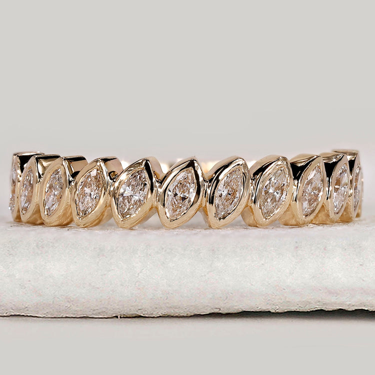 Bezel set marquise diamond band in yellow gold.
