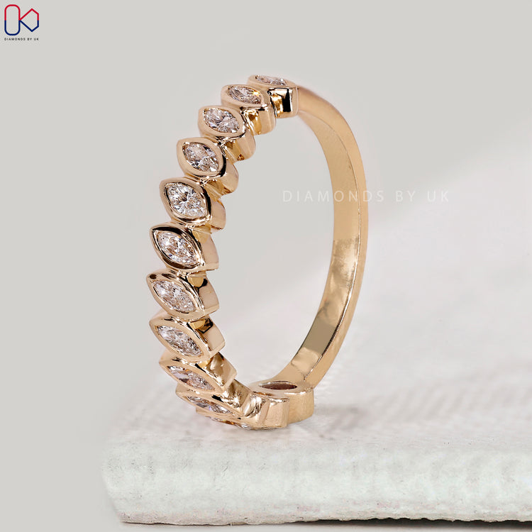 Yellow gold stackable wedding band with bezel set diamonds.
