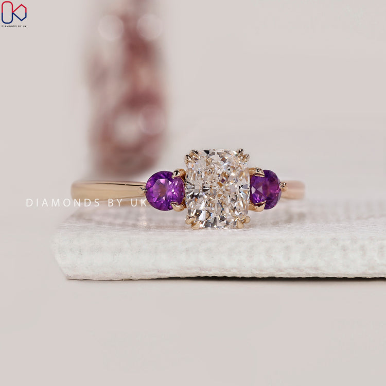 Round side stone engagement ring in yellow gold.
