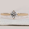 Round cut diamond engagement ring in yellow gold.
