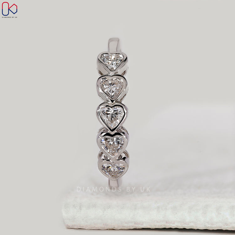 White gold wedding band with heart diamonds.
