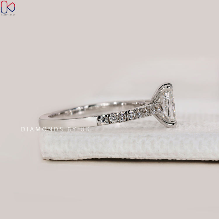 DiamondsbyUK radiant cut engagement ring with pave diamonds.
