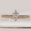 Pear cut engagement ring with tapered pavé band.