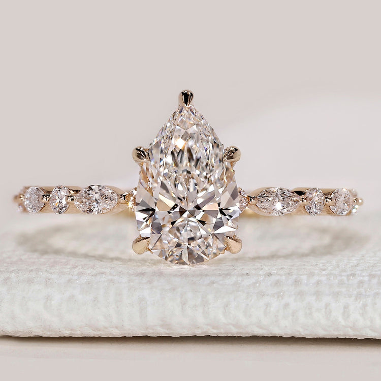 Pear cut ring with hidden halo and marquise pavé.