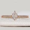 Pear cut engagement ring with tapered pavé band.