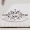 Princess cut diamond ring with round diamond pavé style.
