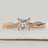 Princess cut ring with twisted pavé diamond band.