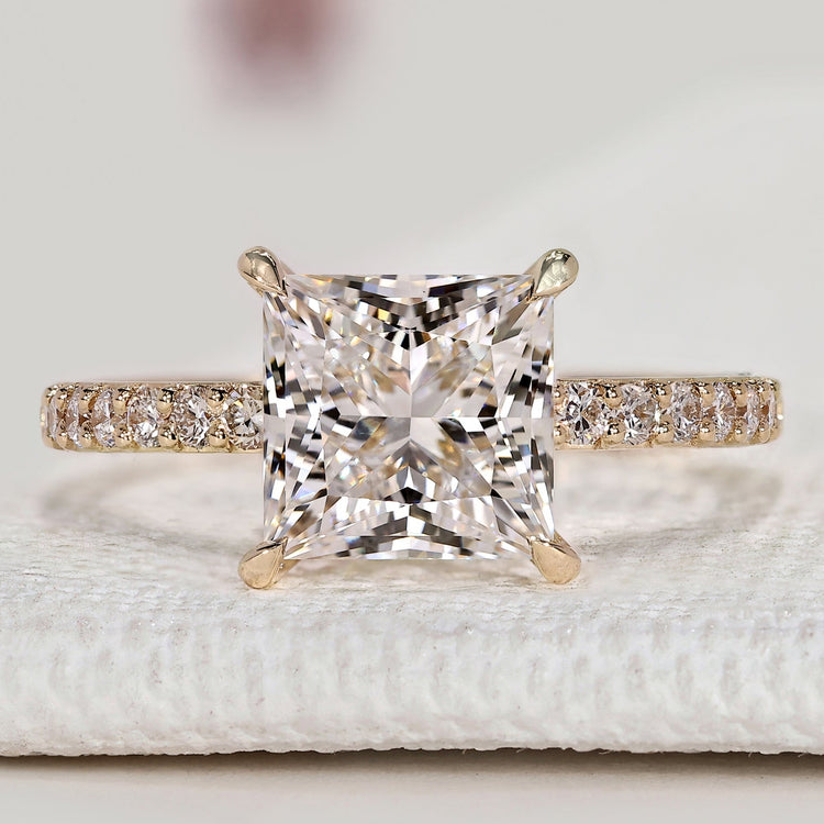 Princess cut ring with round diamond pavé style.