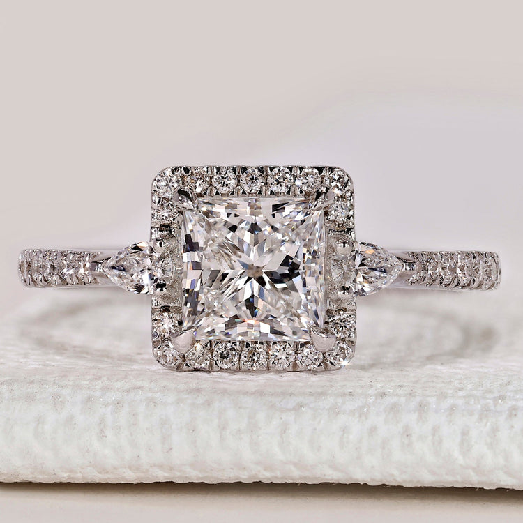 Princess cut ring with two pear side stones and halo.
