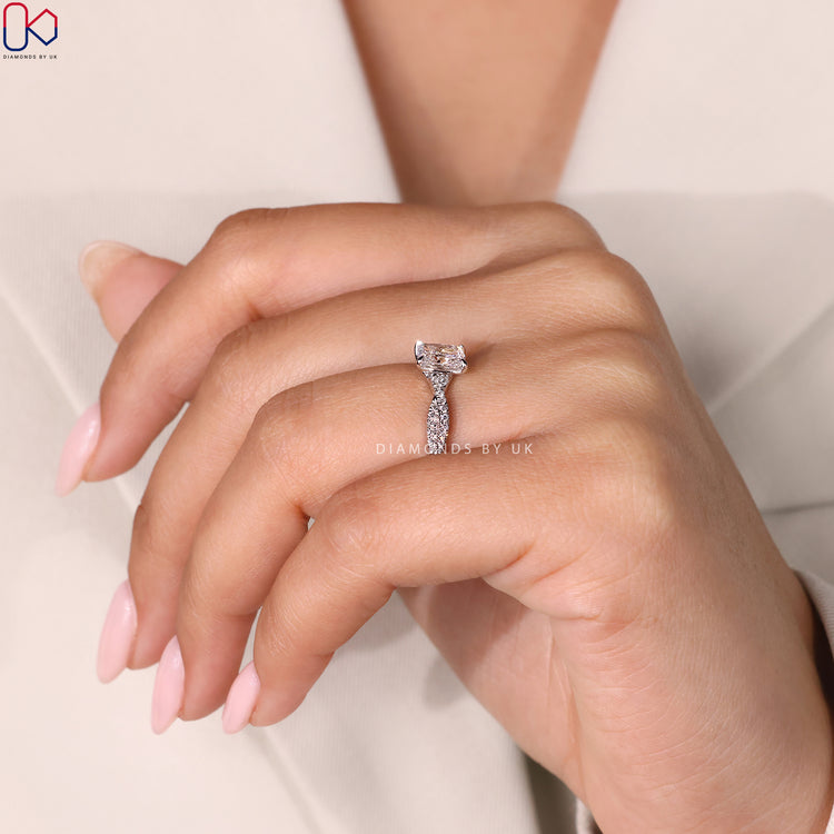 Round Side Diamond Ring featuring an elongated cushion center diamond with a twisted band, set in white gold.
