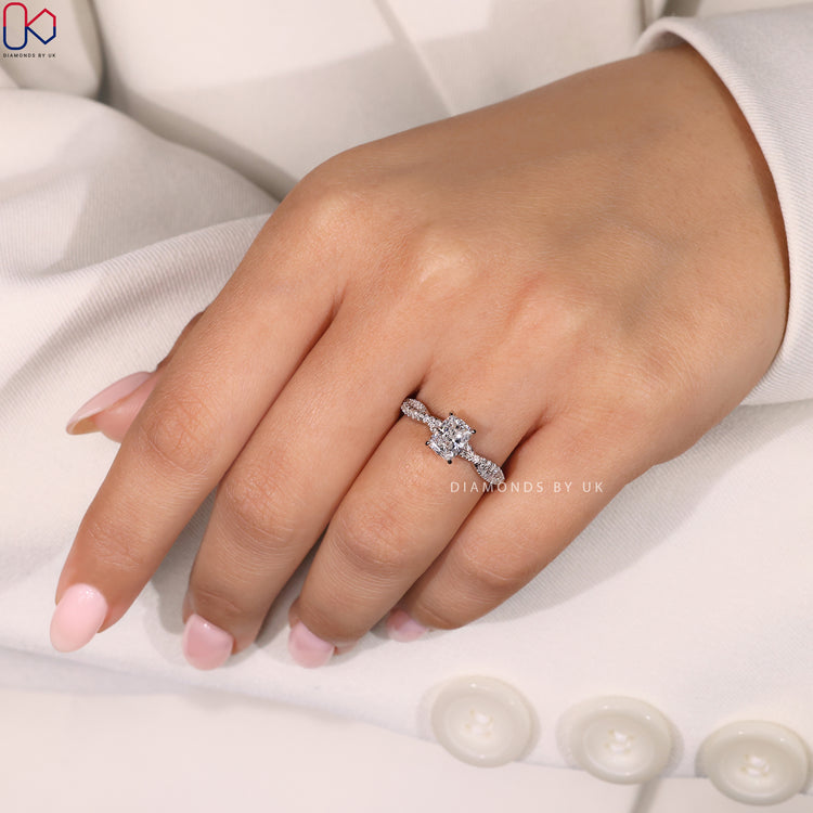 Twisted Pave Band Engagement Ring with a cushion cut center diamond and round side diamonds, set in white gold.
