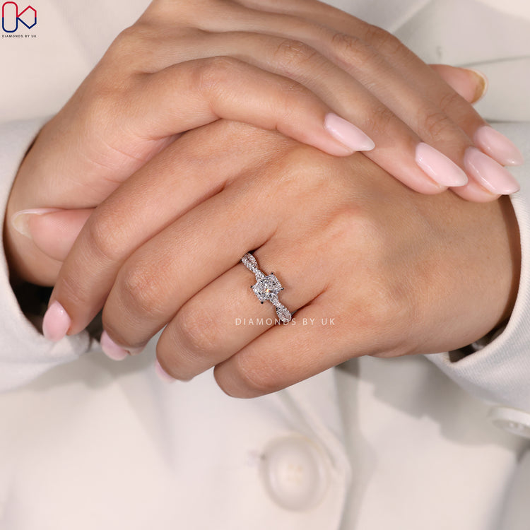 4 Prong Claw Setting Cushion Cut Diamond Ring, featuring round side diamonds and a twisted pave band in white gold.
