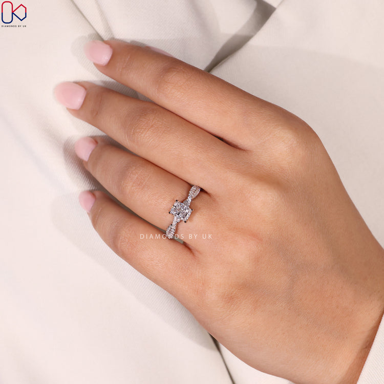 Diamondsbyuk Engagement Ring featuring a cushion cut diamond with round side diamonds, crafted in a twisted pave band in white gold.
