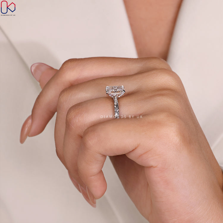 Tulip Ring with Emerald Cut Diamond, side diamonds, and a 4-prong claw setting in white gold.
