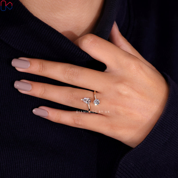 Diamondsbyuk engagement ring with pear and round diamonds in a V shaped prong setting.