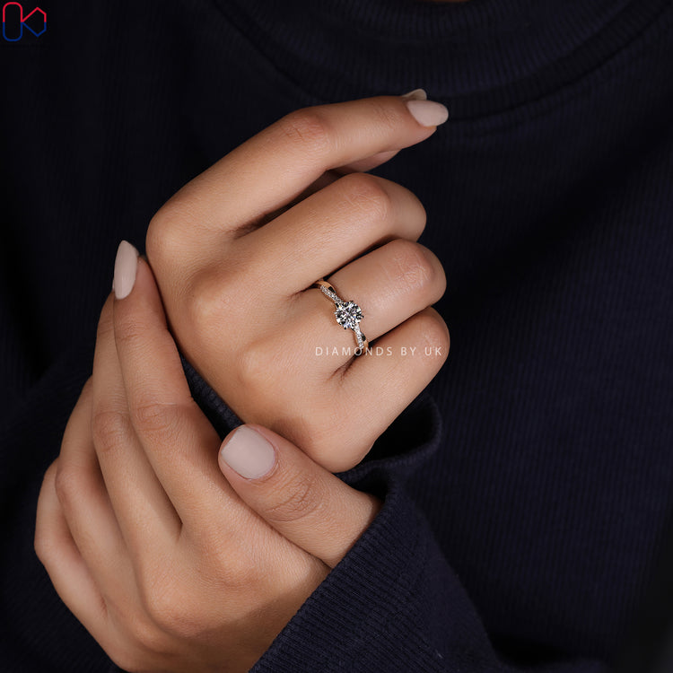 Round cut side stone with diamond engagement ring.
