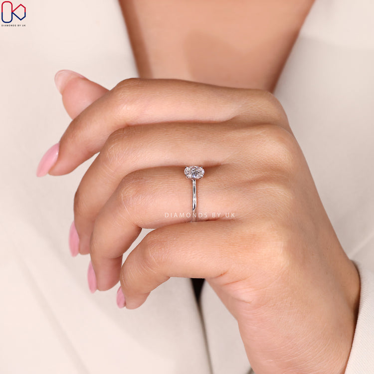 White Gold Ring with Oval Cut Diamond, featuring a cathedral setting and tapered shank for a modern.
