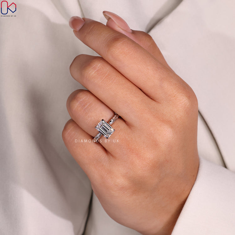 White Gold Ring with an Emerald Cut Diamond and side diamonds, ideal for an unforgettable engagement.
