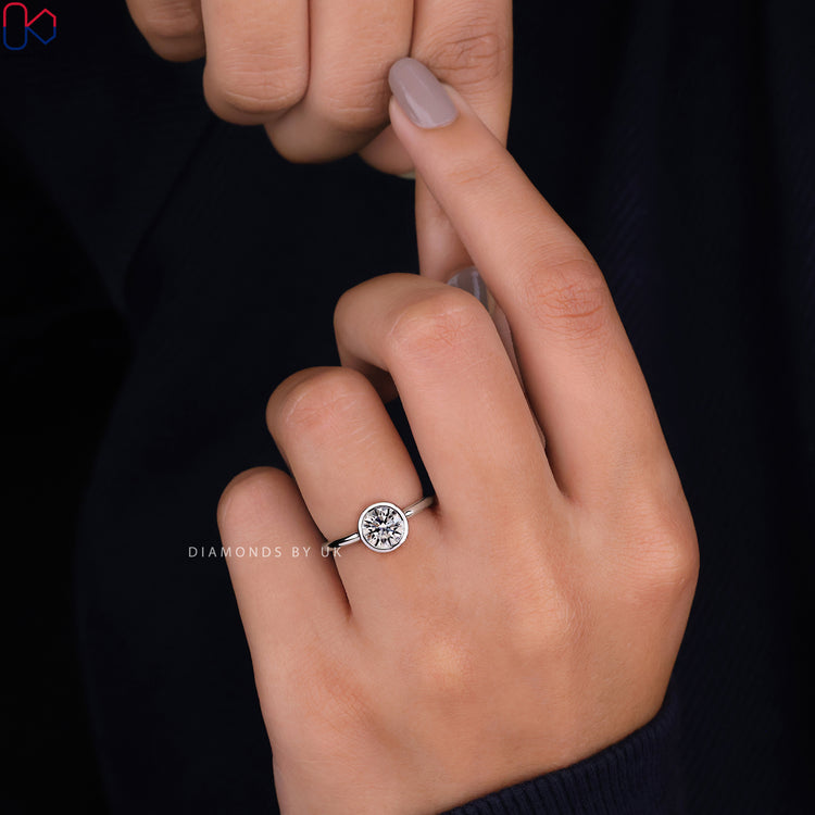White gold engagement ring with a classic bezel setting ring and brilliant round diamond.