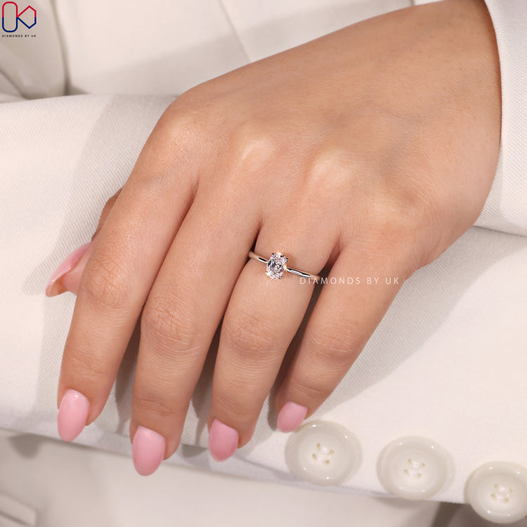 4 Prong Claw Setting with an Oval Cut Diamond, designed in a white gold ring with a tapered shank.