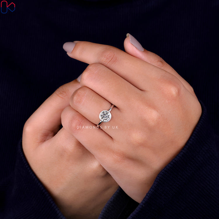 Handmade jewellery featuring a brilliant round diamond engagement ring with a bezel setting ring.