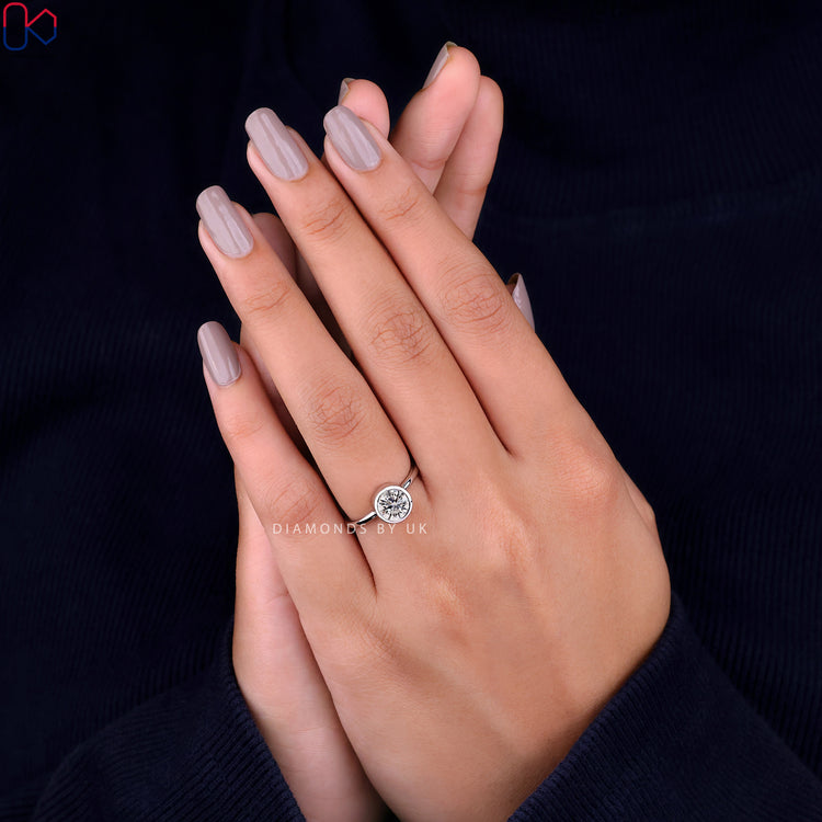 Diamondsbyuk engagement ring with a bezel setting ring and a gorgeous round diamond.
