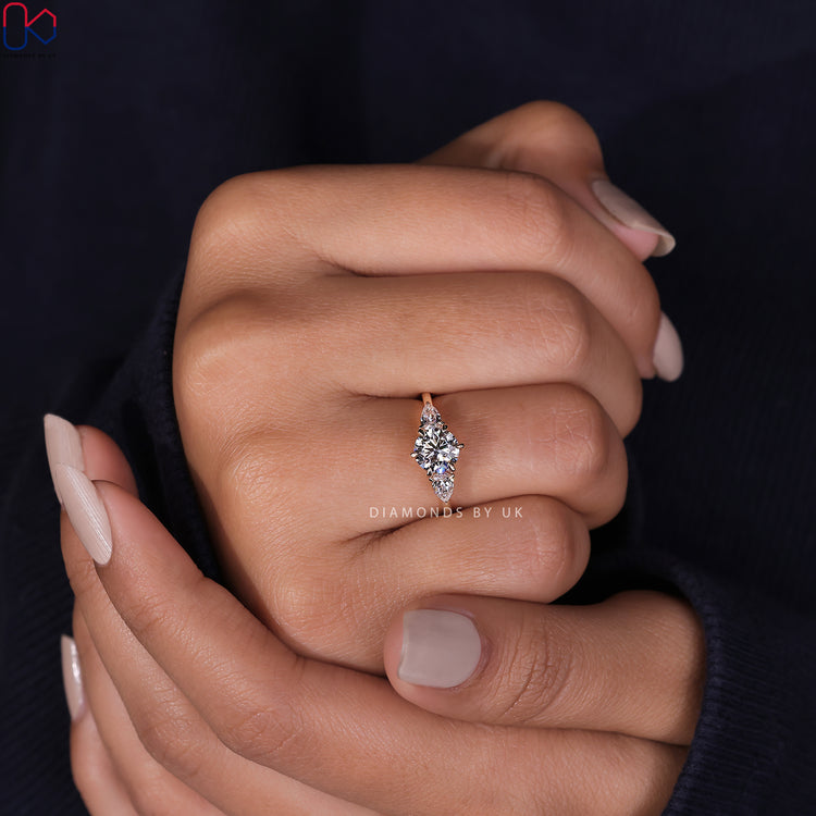 Elegant pear cut ring with round diamond ring and yellow gold ring setting.

