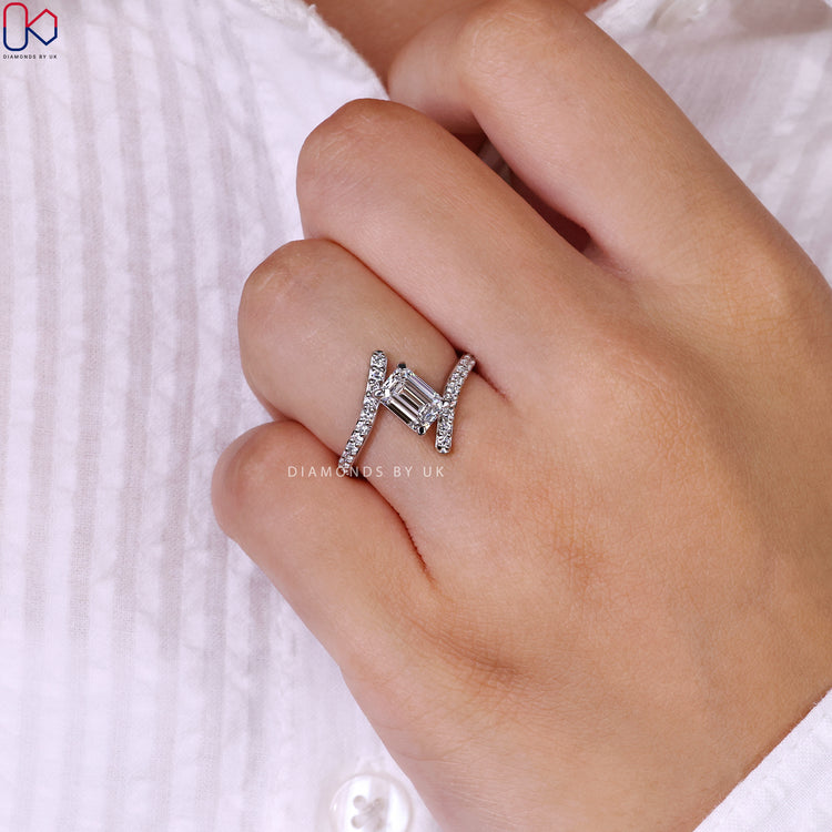 Round diamond pave set ring with emerald cut center.
